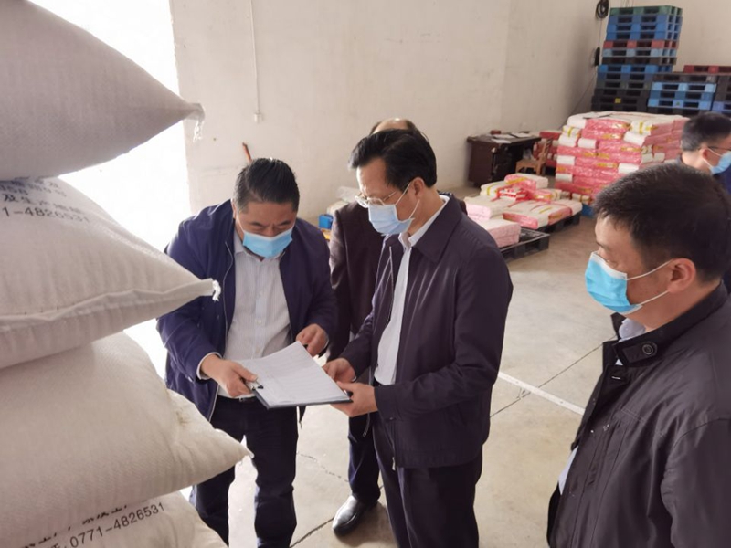 相片5：韦洲民向区粮食局领导介绍大米生产车间储备情况.jpg